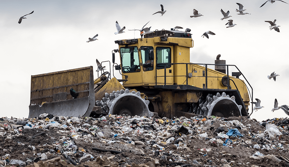 Tractor in landfill removing waste